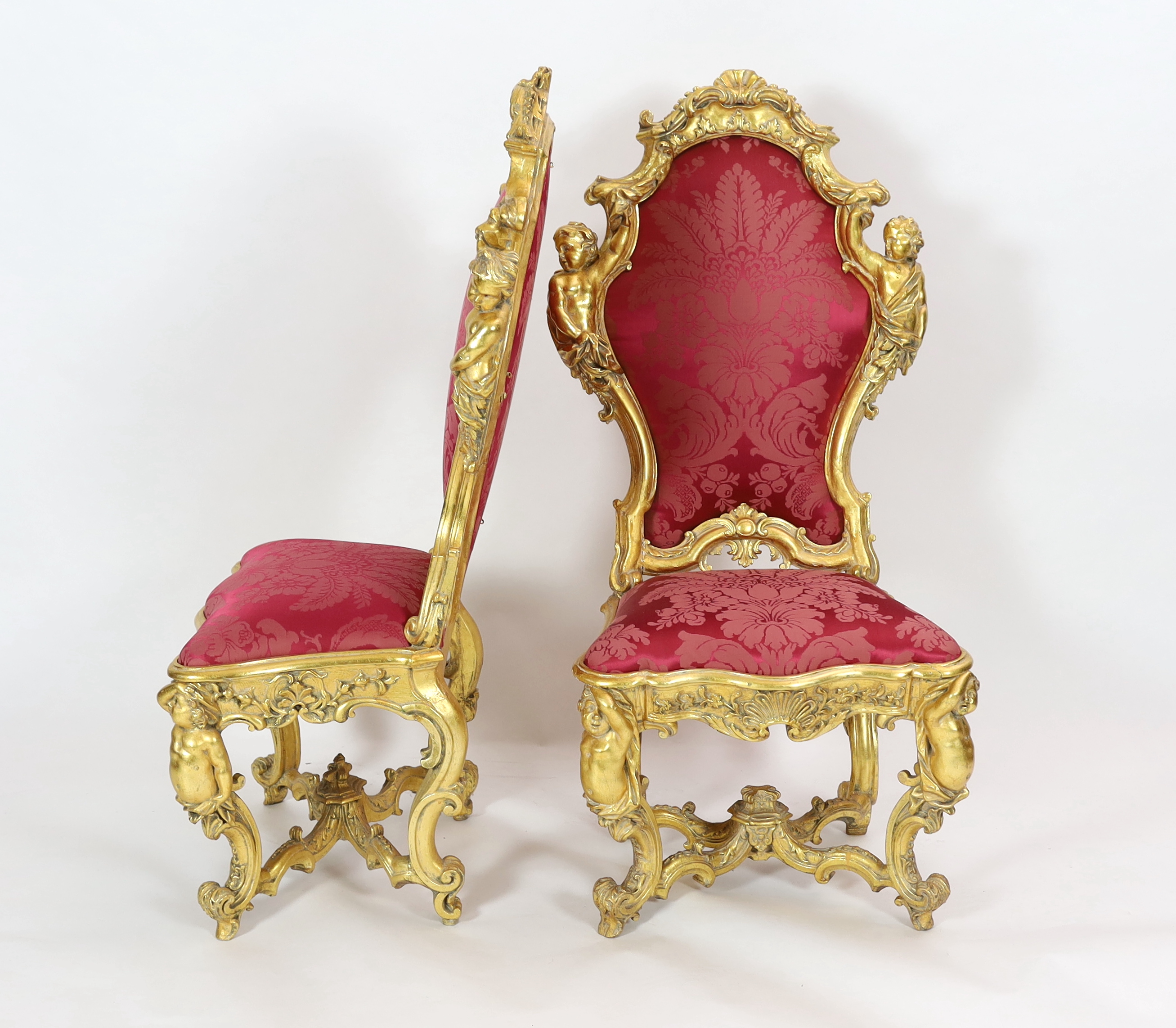 An important pair of late 18th century Venetian carved baroque giltwood throne chairs, the seats and backs upholstered in red floral silk. c.1770, 64cm wide, 55cm deep, 132cm high, Please note this lot attracts an additi
